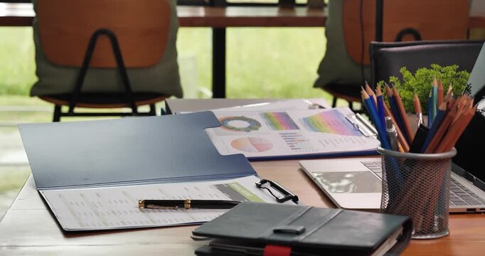 Office laptop business financial document chart and graph on wooden table with coffee cup. Flat lay notebook computer laptop office desk. No people business graph chart mockup on business workspace