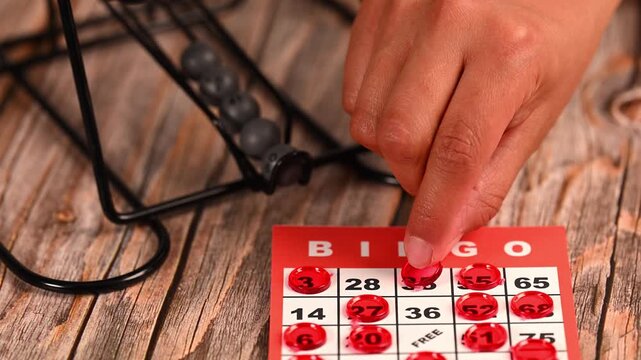 Cropped shot of hands playing a traditional bingo game at home
