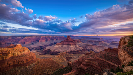 Vast desert canyon at sunset with dramatic sky, layered rock formations and sweeping vista