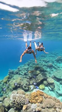 Couple snorkeling together over a colorful coral reef