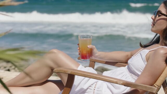 Relaxing woman enjoying a cocktail on the beach