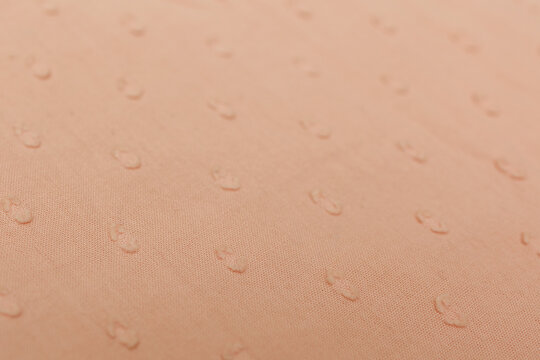 Minimal beige cotton textile with raised dot pattern