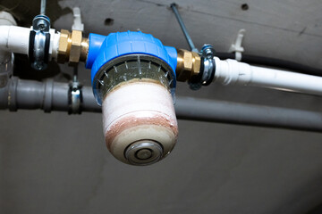 Obraz premium Close up of dirty sediment water filter cartridge in plumbing system