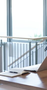Vertical video: Recording is capturing open notebook, pen and laptop on desk by window for stock
