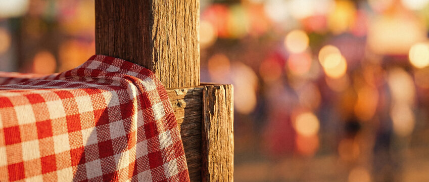 A red and white checkered tablecloth draped over a wooden post in a rustic setting