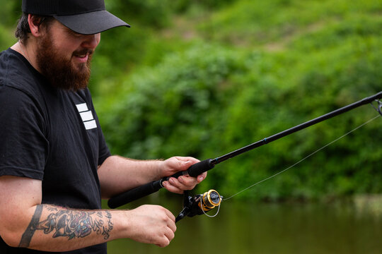 Australian man in his thirties enjoying the outdoors throwing a fishing line in the river