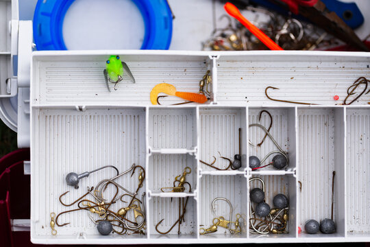 Hooks sinkers and fly in a tackle box for fishing hobby