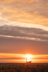 Industrial plant silhouette with smoking chimneys at sunset sky background