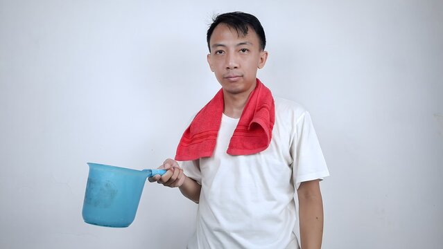 Adukt asian man holding water dipper and red towel on his neck preparing to take a bath isolated on white background. health concept photoshoot