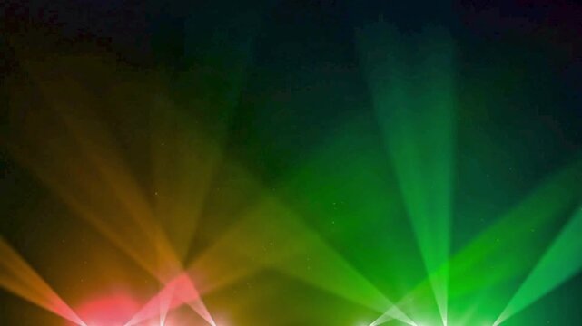 Dynamic multi color stage spotlights flashing and moving across a dark background with particles creating a vibrant concert atmosphere.