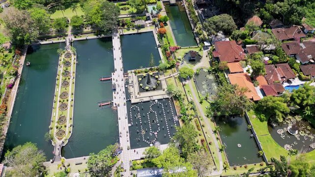 Aerial drone view of Tirta Gangga Water Palace in Karangasem, East Bali, Indonesia. Symmetrical royal gardens with ornamental ponds, fountains, stepping stones, and traditional Balinese architecture s