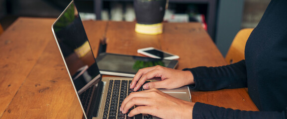 Banner Businesswoman hands type on laptop writing on notebook meeting at office desk. Freelance girl work from home via internet call conference sitting at home office morning time. Close up women