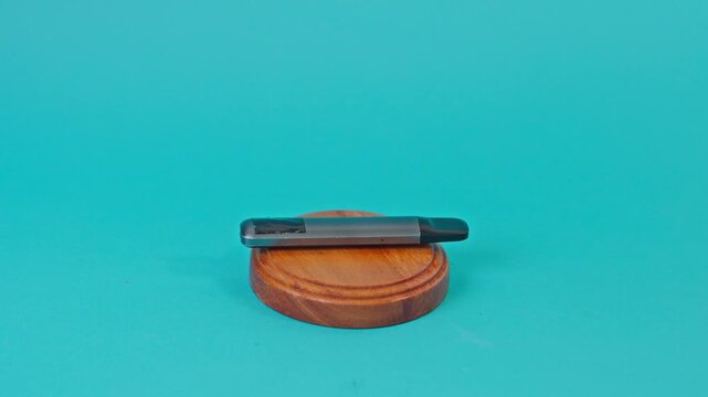 Hand using justice gavel to hit modern e-cigarette pod for Concept of vaping laws