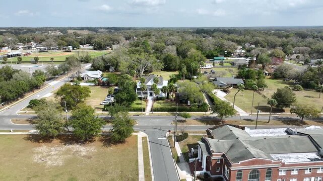 A scenic aerial shot captures the Palm Mansion estate framed by towering trees and a carefully arranged garden ceremony layout.