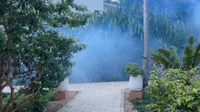 Pest control worker spraying mosquito repellent around the territory of a luxury hotel in Zanzibar, Tanzania.