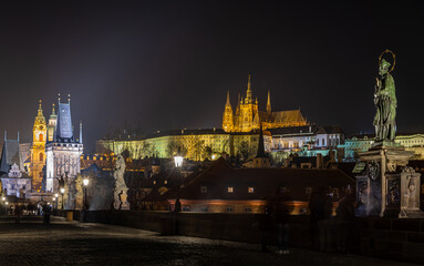 Obraz premium St John of Nepomuk statue on Charles Bridge with Prague Castle at night Czechia