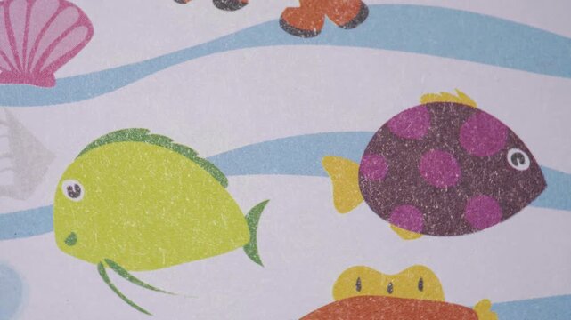 Animated movement over cute nautical background with clownfish and shells, Close up pan of colorful sea life pattern on textured paper