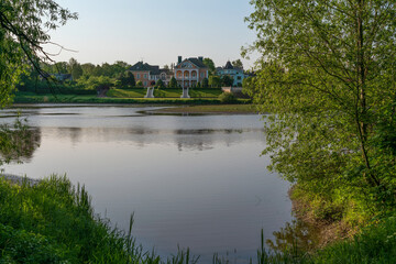 Obraz premium Residential mansion on the shore of the Orlovsky Pond on a sunny summer day, Strelna, Saint Petersburg, Russia