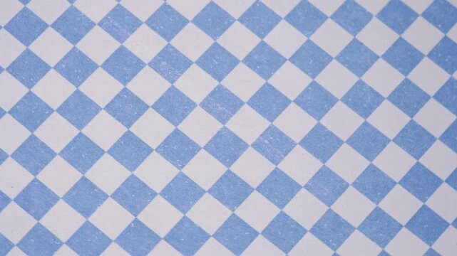 Top view of rotating blue and white checkered pattern background, Rotating geometric blue and white checkered surface for background