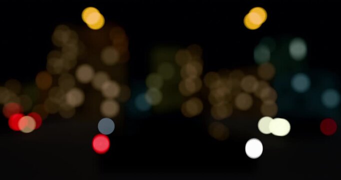 Abstract view of blurred city light of cars. Defocused red lights from moving traffic on a night cityscape. Round colorful bokeh effect on a urban black background. 4K 3D rendering loop animation.