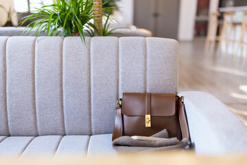 Brown handbag on a gray sofa in a modern interior