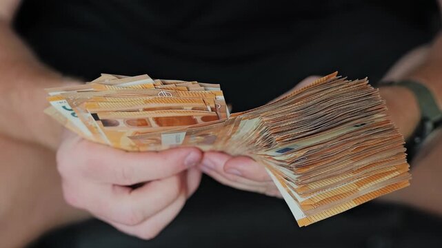 Hands counting euro savings in slow motion symbolizing economic anxiety