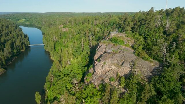 Aerial pull-back drone reveal from Kopparklinten rocky cliff viewpoint over G&ouml;ta &auml;lv river and Olidan hydroelectric power station in Trollh&auml;ttan Sweden