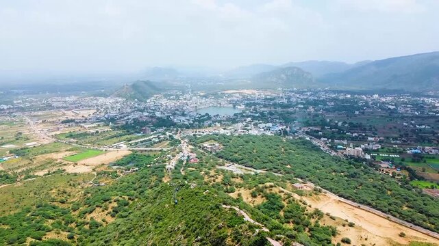 Aerial drone view from Nahargarh Fort showing Jaipur city skyline surrounded by hills roads and urban landscape in Rajasthan India