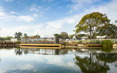 Fototapeta premium Tranquil Park Landscape with Reflections and Tents in Background
