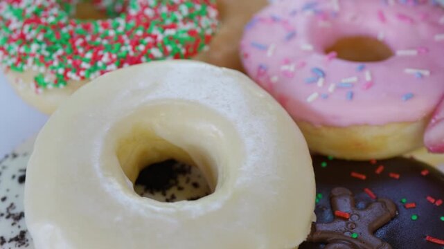 Extreme Closeup View of Hand Picking Pile of Donut with Multiple Topping 