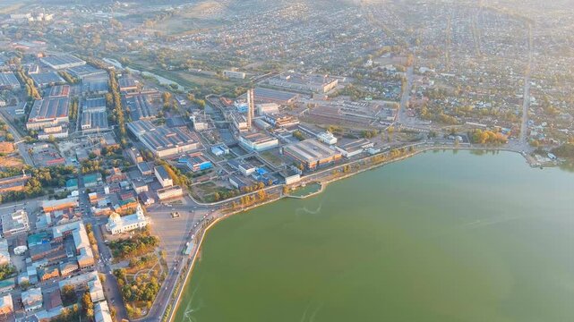 Russia, Votkinsk. Embankment with a dam and factories. Votkinsk is a city in the Udmurt Republic. Sunset time. Drone footage