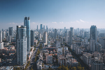 Fototapeta premium Modern cityscape with numerous skyscraper buildings under clear blue sky, showcasing urban density and architectural variety in bustling metropolitan area