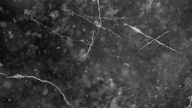 Dark Textured Surface with Cracks and Light Spots image