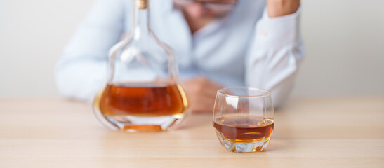 Stressed man drinking cognac alone with problem. Exhausted drunk man looking stressed and sleepy....