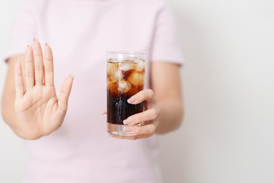 Healthy woman hand stop sign to refuse soft drink and soda, say no to sugar and carbonated beverage, healthy lifestyle, Acid reflux, Heartburn and Gastritis concept