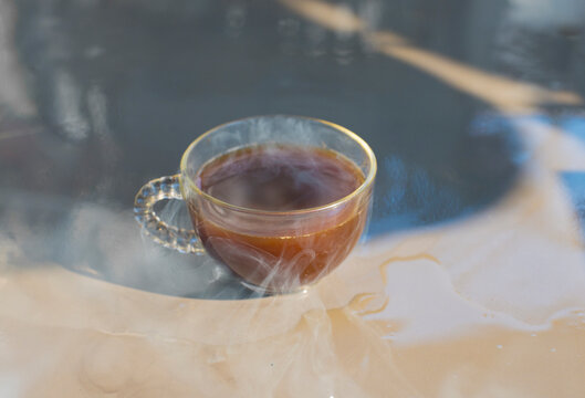 Cup of hot coffee with steam on the table in the morning