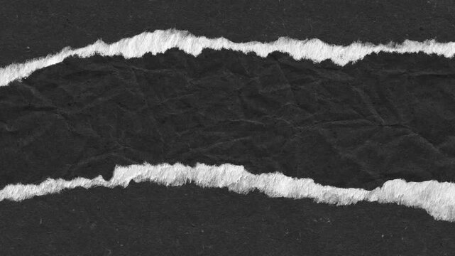 Abstract composition of torn paper revealing a contrasting white texture against dark black background