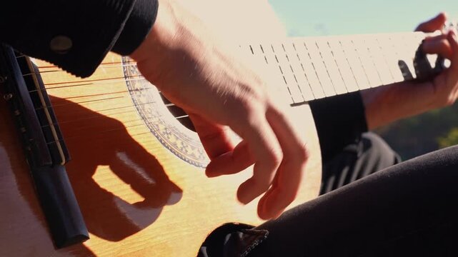 Close up hands of playing string guitar outdoors in autumn forest. Concept of sound therapy, mental health and wellness rituals. Calmness tranquility audio-sensory practices. Aura farming energy