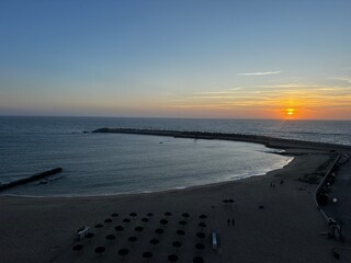 Sunset over the Atlantic Ocean along the beach in Ericeira, a scenic seaside destination known for surfing and dramatic coastal views in Portugal. © Julia