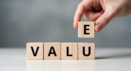 Naklejka premium Hand placing wooden block letter E above value blocks concept