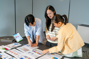 Asian digital marketing agency team analyzing SEO and ads performance on table, Young business professionals discussing campaign metrics, conversion rate and online marketing strategy concept