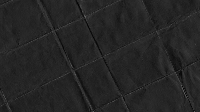 Abstract textured black paper folded in a grid pattern creating geometric background
