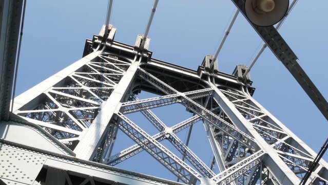 Williamsburg Bridge from Manhattan to Brooklyn, New York City, USA. Architecture of United States, tourist landmark. Metallic cable-stayed bridge. Cables and sky from pedestrian path. Low angle.