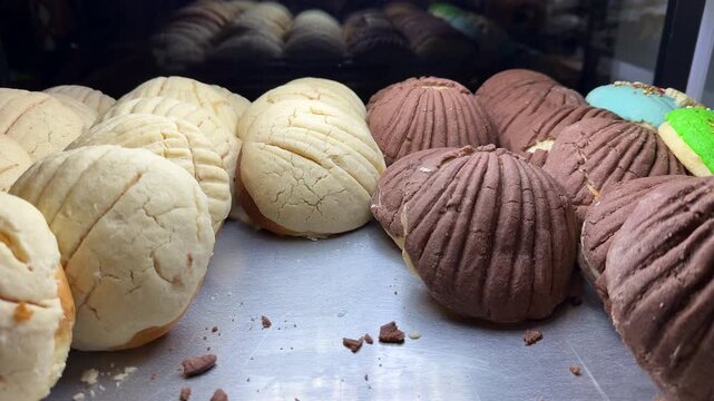 Pan dulce típico mexicano sobre charola en panadería típica de méxico conchas blanca y rosa deliciosas suaves y esponjosas reposteria tradicional mexicana 