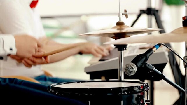 making new song music with band in studio Drummer beats drumsticks on cymbals and drums Knocks the rhythm into the drum with sticks Bright color