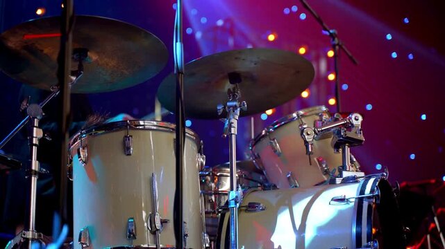 motion of drumsticks in their hand Young Man Playing Drums And Cymbal In Studio The stage is illuminated with multi-coloured lights A drummer hobby