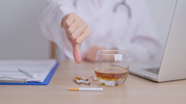doctor hand show thumb down to refuse whiskey and breaking cigarette, quit smoking and drinking for healthy liver and lung, World No Tobacco and  No Alcohol Day and stop alcohol addiction concept