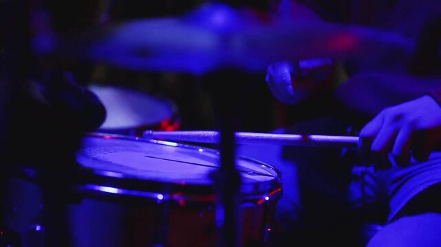 Close up view of young man playing drums with drumsticks while rehearsing in music studio Man with drum kit playing music practicing in a music studio