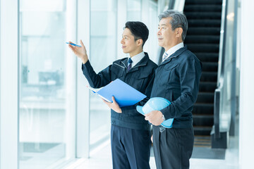 現場で打ち合わせする作業服のビジネスマン