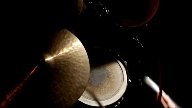 Close-up of a cymbal on a drum set shrouded in smoke Slow motion American man playing drums in music rehearsal studio Male hitting drum metal cymbals